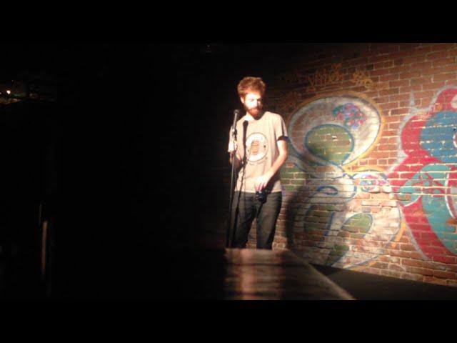 Ryan Bourassa tells jokes in an LA Art Warehouse