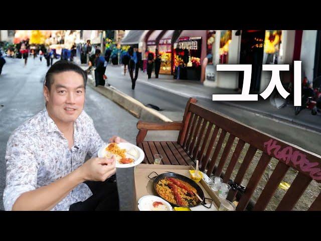 Eating Paella sitting on pavement in Spain