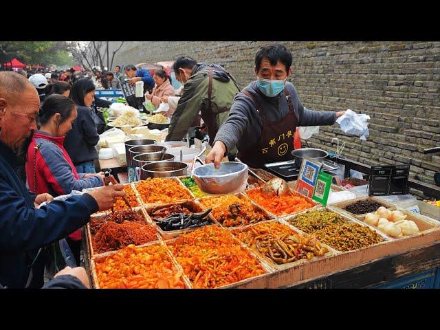 The morning market in Xi'an, China, is crowded with people under the ancient city wall