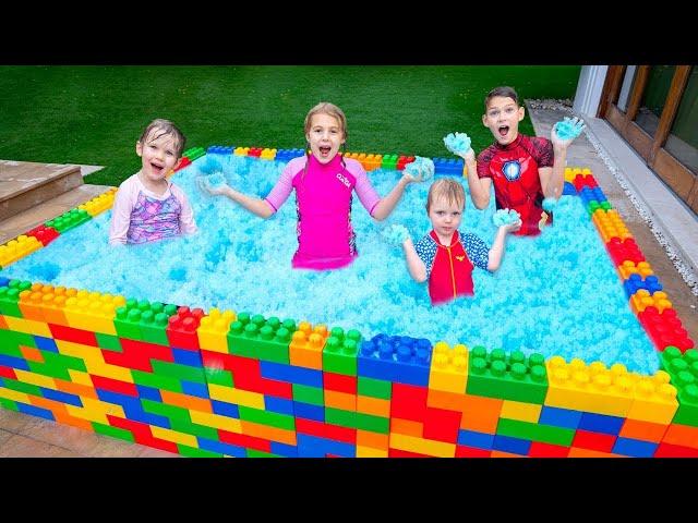 Kinder lernen im Pool schwimmen und spielen mit Wasserspielzeug  Vania Mania DE