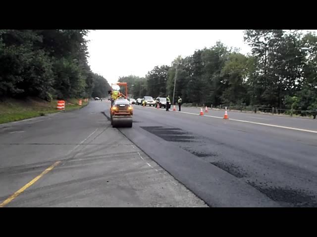 Asphalt roller compacting asphalt on a utility trench repair