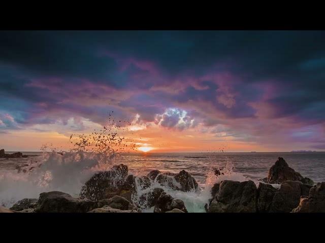 Dramatic sunset on a tropical beach with rocky shoreline in 4K