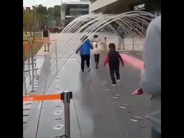 Kids try to outrun a fountain