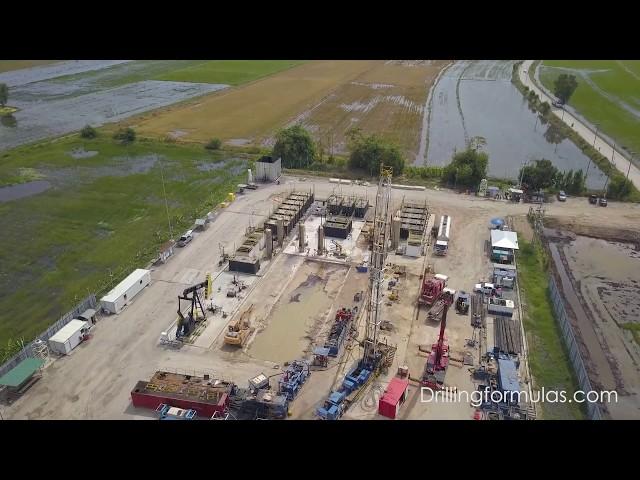 Fly over the land rig located in the middle of flooded rice field (Land rig aerial view)