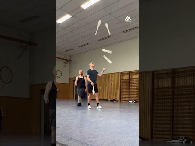 Duo Performs Juggling Trick With Five Clubs