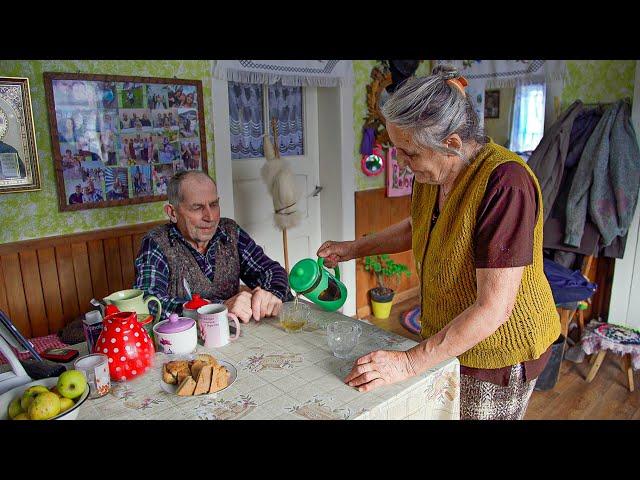 Happy old age of an elderly couple in a mountain village in winter far from civilization