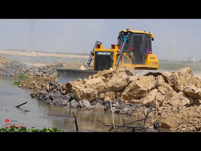 Show Wonderful Stronger Shantui Heavy Bulldozer Pushing Rocks In Water With Dump Truck Unloading