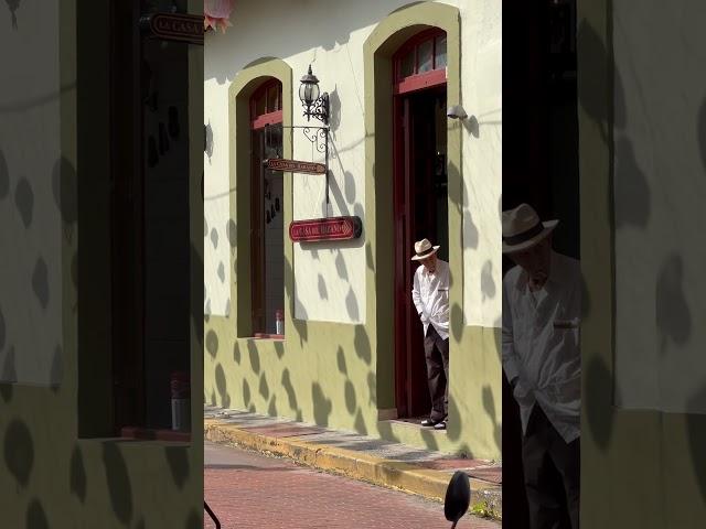 A man with a cigarette and Panama hat