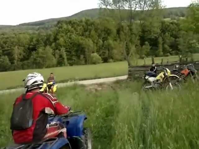 Yamaha Grizzly up on hill with 2 person