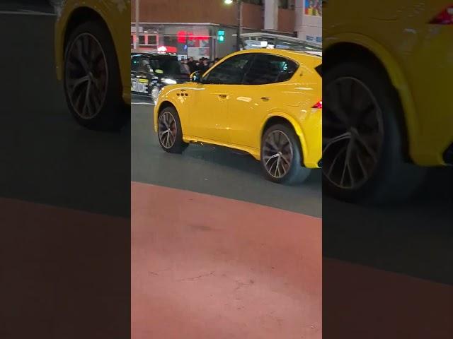 A Yellow Nice Car passing through Shibuya. Tokyo, Japan.