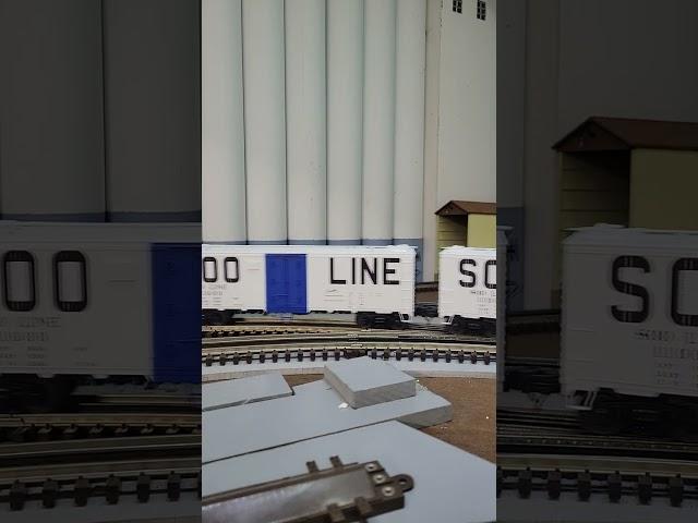 Lionel Soo Line RS-27s running a 1970's freight train past grain silos