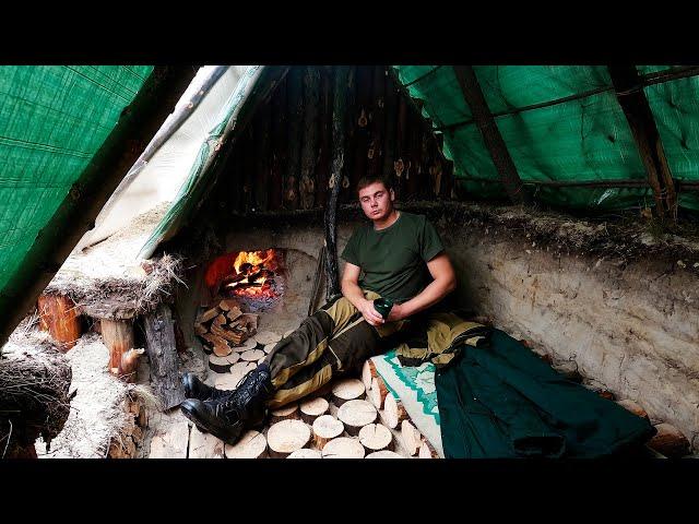 Building a warm survival shelter in the ground, fireplace made of stone and clay, cooking