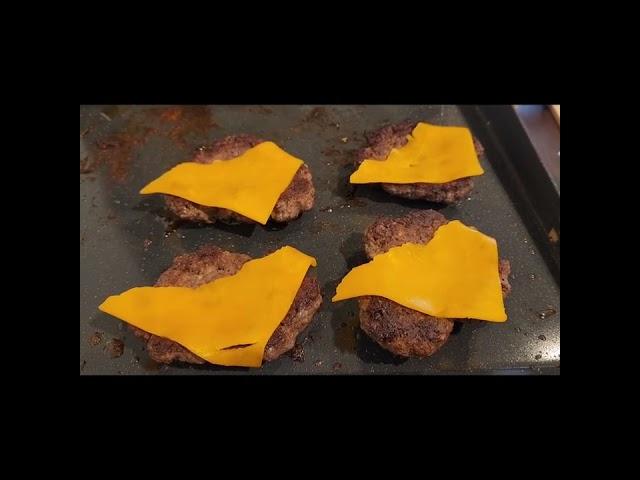Blackstone cooking smashburger with bacon