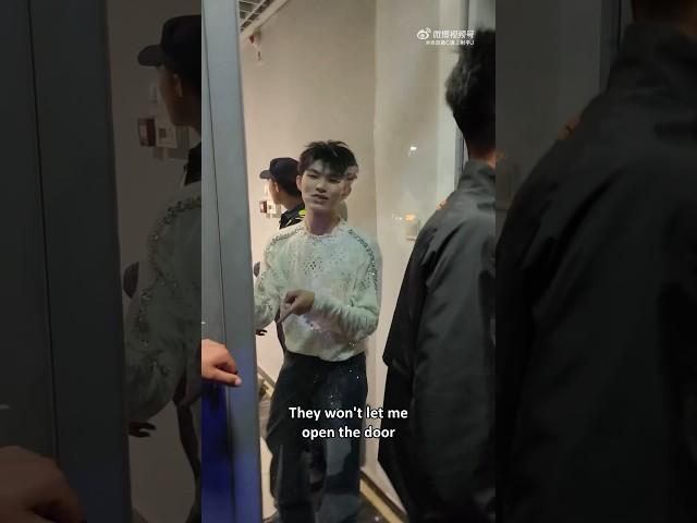 an idol talking to fans through a glass door cos security wouldn't let him out #junliu #刘隽