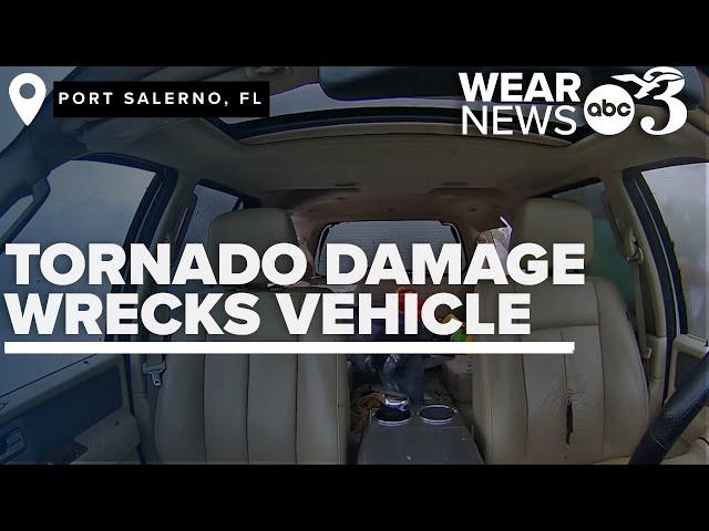 Inside car perspective shows Florida tornado debris severely damage vehicle