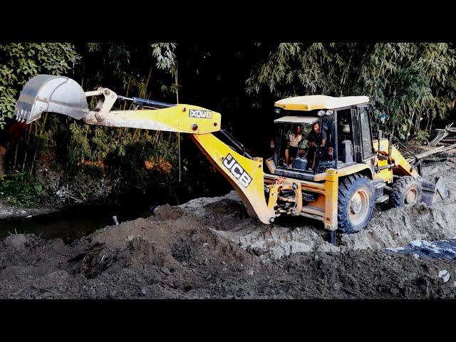 JCB Backhoe Loaer Working Near The River To Build The Village Road