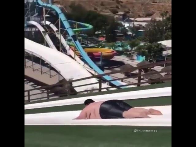 A fat guy going down on the water slide and this happen