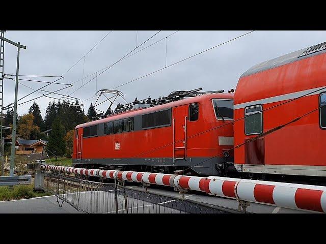 Class 111 "Kleeblatt" travels with Regional Express across a level crossing in Klais (Bavaria)