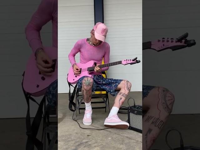 MGK playing his pink guitar 