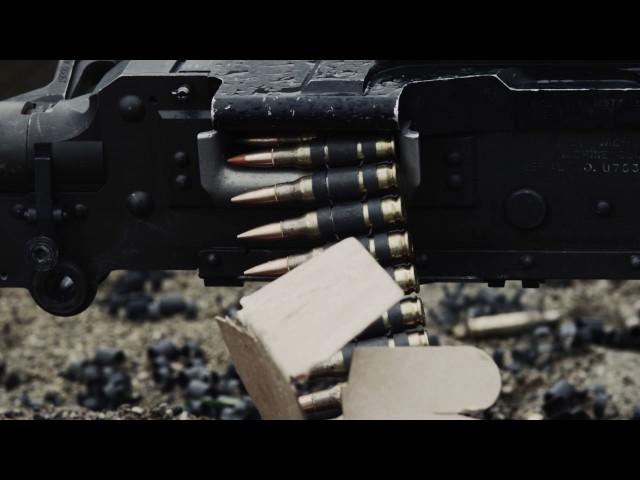 Shot of a belt-fed machine gun as it is fired.