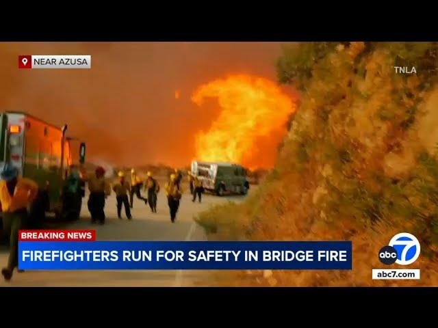 Firefighters run from flames as wildfire advances in Angeles National Forest