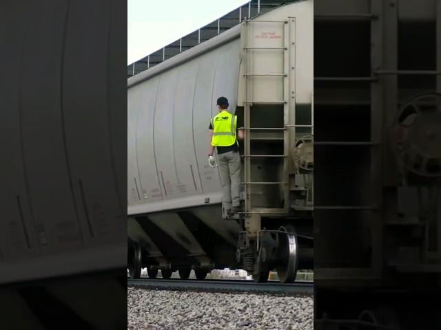 The conductor rides the bottom of the grain train to the customer
