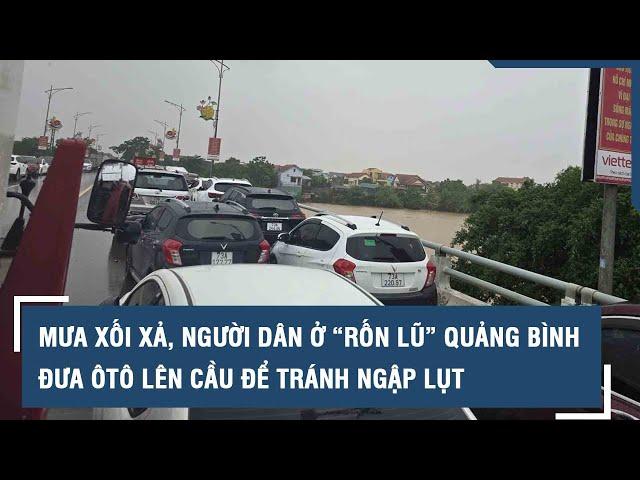 Mưa xối xả, người dân ở “rốn lũ” Quảng Bình đưa ôtô lên cầu để tránh ngập lụt