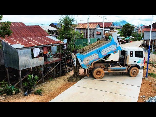 Drop the dirt in front of the home adjacent to the road to bury the pillars in front of the steps.