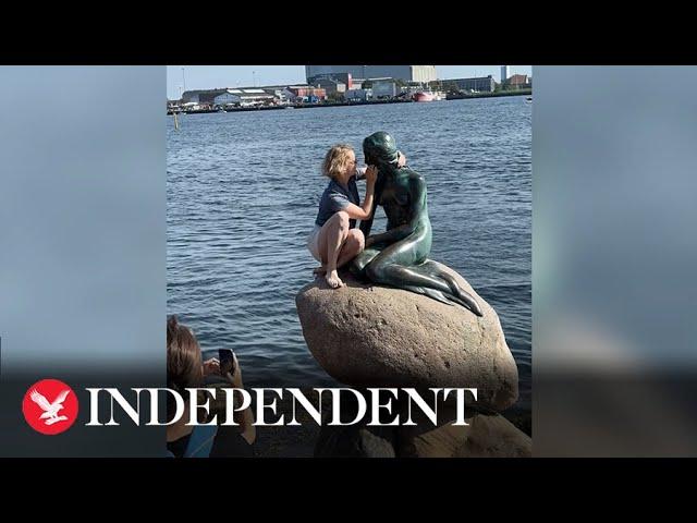 Tourist booed as she climbs Copenhagen's Little Mermaid statue despite warnings