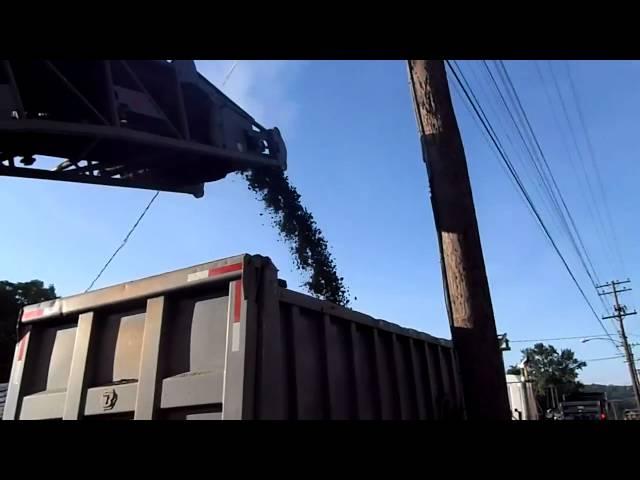 The conveyor of an asphalt mill loading a truck