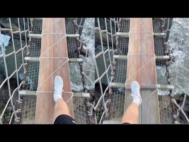 Hiker Crosses Rope Bridge Across Ocean Water