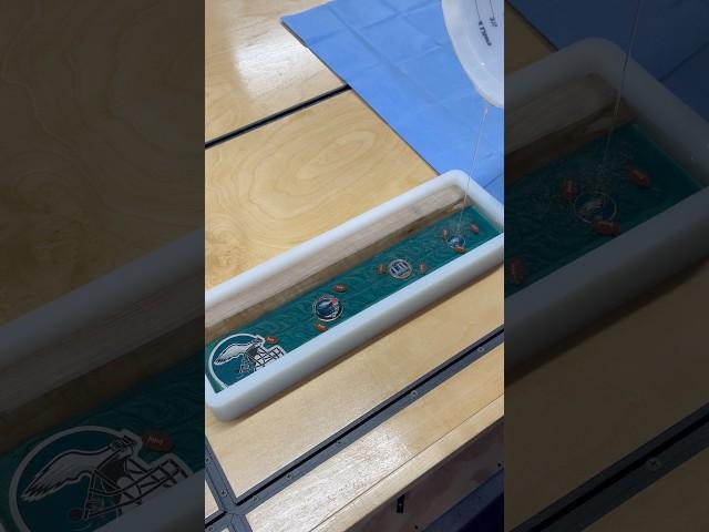 Crystal-clear epoxy pour over Philadelphia Eagles collectibles—watch that deep shine!