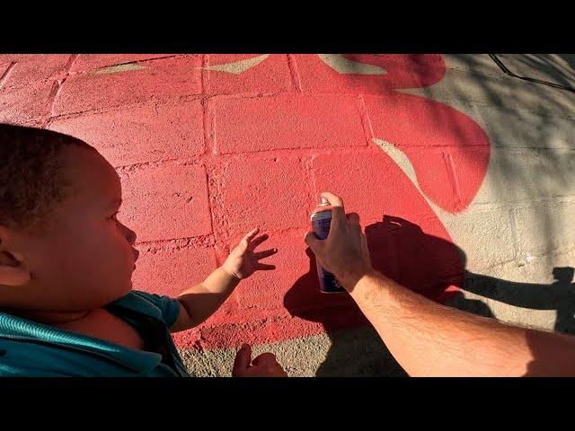 Baby Helps Paint Graffiti Letters on Childrens Park