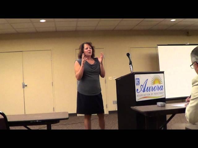 Sandy Anderson, 8z Real Estate, addresses Aurora Board of Realtors