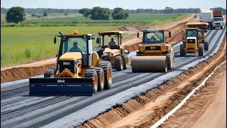 Amazing road construction in a rural area. The large yellow motor grader is working on a dirt road