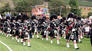 Lonach Highlanders led by Lonach Pipe band arrive at the 2019 Gathering and Games in Strathdon