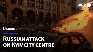 Damage buildings and burning cars in Kyiv city centre following Russian attack | AFP