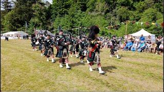 Drum Major leads Lonach Pipe Band march out after display during 2024 Drumtochty Highland Games