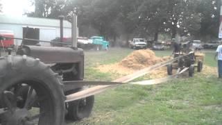 John Deere running a hay press.