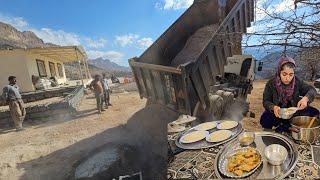 Heavy machinery and teamwork: delivering sand and building a new house.