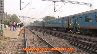 Man risking his life hanging on high speed 12004 Lucknow Swarna Shatabdi Express.