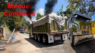 Custom-built international Cabover truck, roaring up a steep hill with its mighty engine.