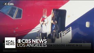 Walker Buehler holds up Commissioner's Trophy as Dodgers land at LAX