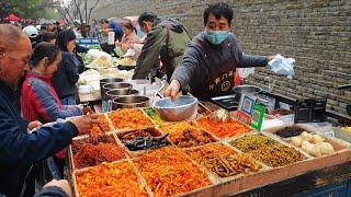 The morning market in Xi'an, China, is crowded with people under the ancient city wall