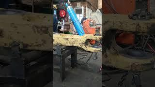 WELDING EXCAVATOR'S AXLE EYES BEFORE BUSHING IN THE MECHANICAL WORKSHOP BY EXPERT WELDER