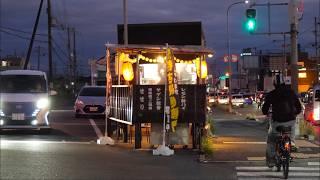 A vibrant, bustling Japanese yakitori stall sandwiched between narrow, lively streets.