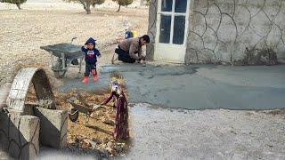 Zahra and Masoud's collaboration in spreading cement on the porch floor