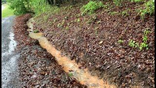 Mucking out a driveway drainage ditch