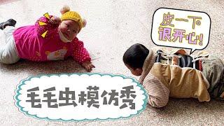 Xiao Fengfeng and Xiao Huihui lying on the ground imitating caterpillars