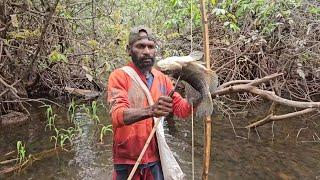 Archery and grilling fish in the forets of Papua